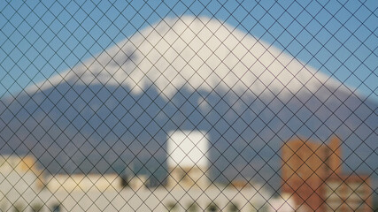 Snow-covered mountains fuji appear in the distance, blurring behind the wire-reinforced front window.