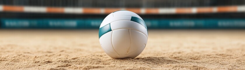 A volleyball rests on sandy court, ready for a beach volleyball match in an outdoor arena.