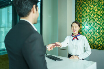 Businessman and his assistant are proceeding a checkin at airline counter in the airport.