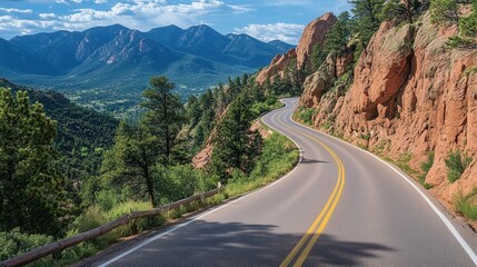 Fototapeta premium An open road through a mountainous region with a scenic view under a bright, blue sky.