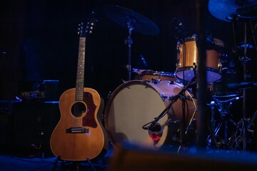 A Guitar and Drum Set on a Dark Moody Stage at a Venue for a Local Live Music Concert