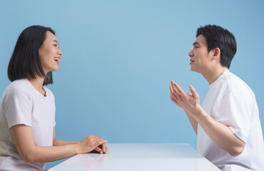Engaging conversation between two young adults in a modern setting with a light blue background
