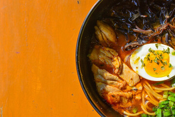 Top view of Curry Ramen with Tori in the black bowl. Half view, close up, copy space, above, high angle, free, negative.