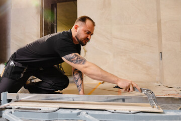 Construction Worker Cutting Ceramic Tile Using Tile Cutter in Bathroom