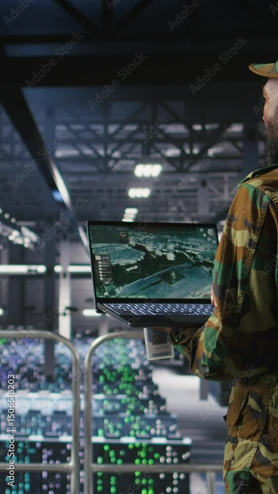 Poster vertical video military technician reviewing tactical dashboard on laptop screen inside secure serve