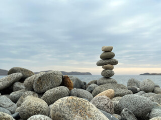 Cairn of smooth stones on the seashore. Harmony, meditation, contemplation.