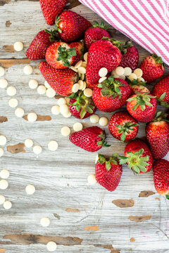 fresh strawberries and white chocolate bits on a wooden background
