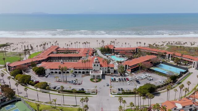 Experience the breathtaking aerial views of Oxnard, California, highlighting the beautiful coastline, shimmering pools, and iconic palm trees that define this enchanting beachside city