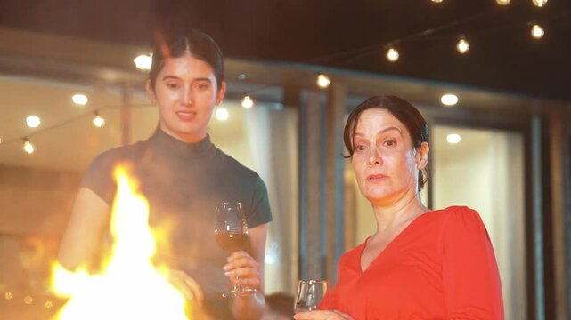 Family celebrate holiday. Mother and grandmother drink wine, cook food while father, grandfather and girl have dinner party food. Outdoor activity spend time together cross generation gap. Divergence.