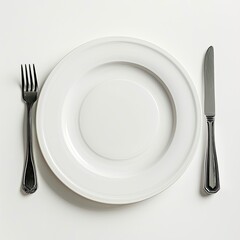 A simple dining setup featuring a white plate, fork, and knife on white background