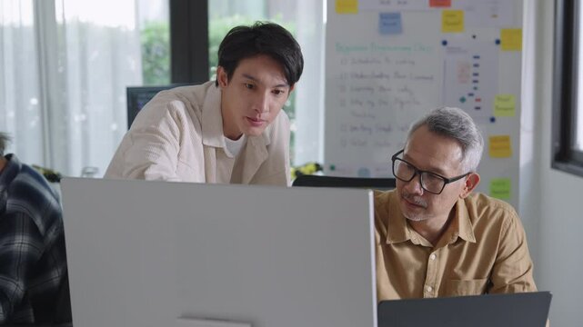 Group of asian senior in a collaborative software development analyzing  flowcharts  during a bootcamp training