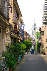 Solitary worker walks down a residential side street in Shinagawa, Tokyo.