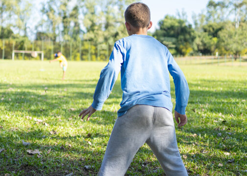 Brazilian children playing soccer on a grass field