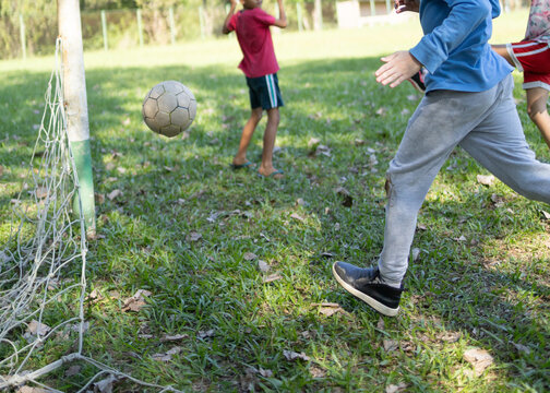 Brazilian children playing soccer on a grass field