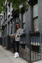 A joyful young woman on the streets of New York, in a plaid jacket