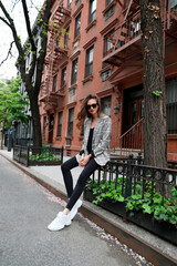 A joyful young woman on the streets of New York, in a plaid jacket