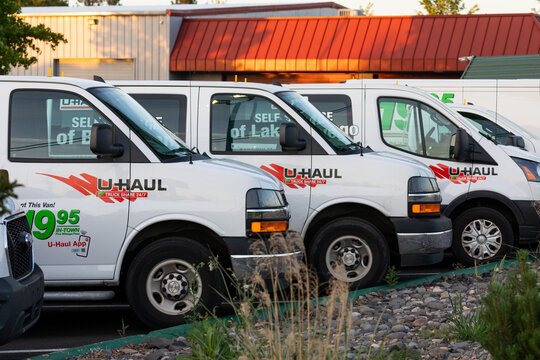Beaverton, OR, USA &ndash; May 24, 2025 &ndash; Row of U-Haul cargo vans and box trucks parked at the rental lot, showing clear company branding, logos, and promotional pricing decals under evening light