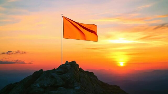 Orange flag waving on mountain top at sunrise: achievement and success concept