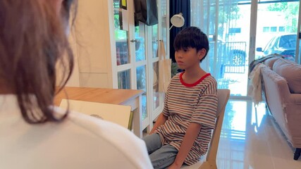 The Southeast Asian single mother is drawing a picture of her son while he sits still. - Powered by Adobe