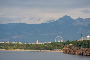 Konyaaltı Beach and the Ferris wheel are seen from Antalya coastal cliffs