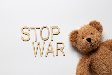 Teddy bear and the phrase stop war on a white background, war, suffering of children