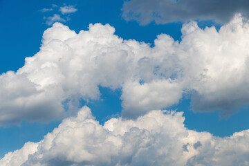 Fluffy white clouds against bright blue sky in daylight