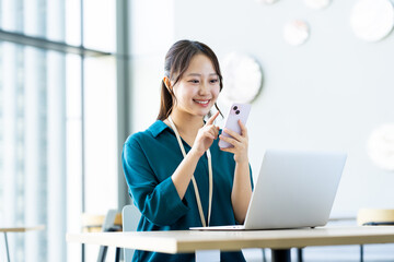オフィスでスマホを見る若いエンジニア　撮影協力:スカパー東京メディアセンター