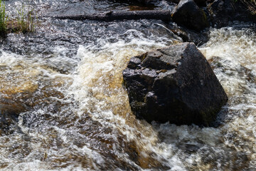 waves hitting boulder in a creek