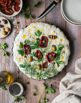 Top view focaccia bread dough decorated with flower design.