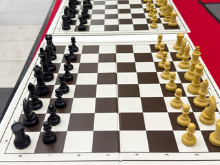 Chess tournament setup with black and white pieces on two boards
