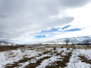 Snow covered mountains in Kyrgyzstan under cloudy winter sky peaceful rural landscape