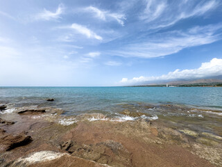 Rocky shore and clear water of Issyk-Kul under a vast sky