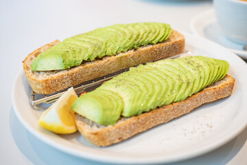 Top down view of two toast bread with sliced avocado topping. Tsuen Wan, Hong Kong. Selective focus, blurred background.