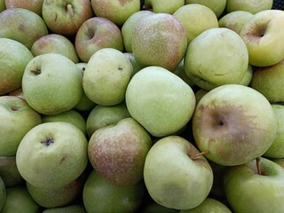 Piles of Fresh Local Green Apples in Supermarket Fruit Display.