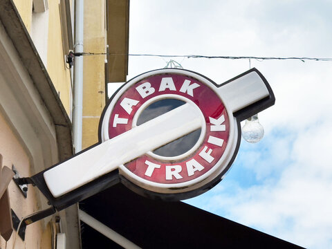 Tabak trafik store sign with red and white design against cloudy sky