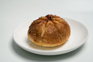 golden-brown loaf of bread on a white plate in natural light