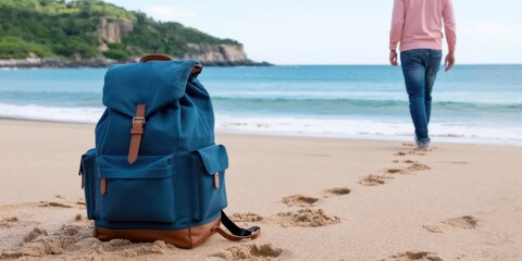 A blue backpack rests on a sandy beach, with a person walking away into the distance, leaving footprints. Symbolizes travel, freedom, and seaside adventure.