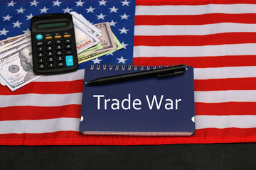 Trade war with USA : The word trade war is written on a notepad with the American flag.
