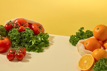 A top-down view of neatly arranged fruits and vegetables — kale, lemon, cherry tomatoes — on a...