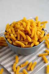 Dry Fusilli Pasta in a Bowl, side view. Close-up.