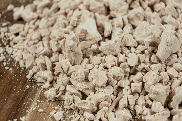 Compressed fresh yeast cubes close-up on a wooden background.
