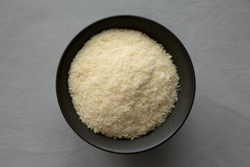 Organic Parmigiano Reggiano Parmesan Cheese Grated in a Bowl, top view.