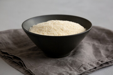 Organic Parmigiano Reggiano Parmesan Cheese Grated in a Bowl, side view.