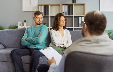 Family couple attends therapy session with psychologist during relationship conflict or quarrel, receiving assistance from doctor in a professional setting with focus and care daily.