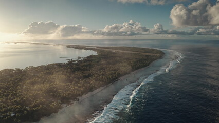 A stunning aerial perspective captures a pristine tropical island surrounded by turquoise waters. Waves gently lap at the shore as the sun sets, casting a warm glow over the lush greenery.