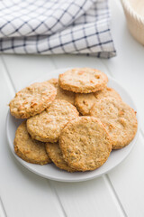 Sweet oatmeal cookies on plate on white table.