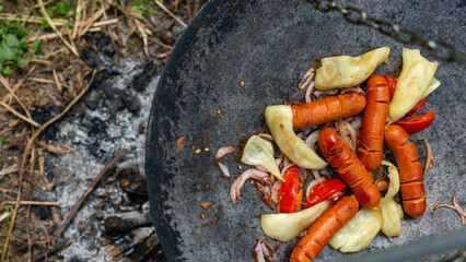 Grilled sausages and peppers on rustic iron pan..