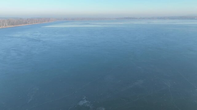 Frozen lake in the morning fog on a sunny day aerial shot from a drone. Pogoria lake in winter, Dabrowa Gornicza, Poland. Ice shrouded lake in fog.