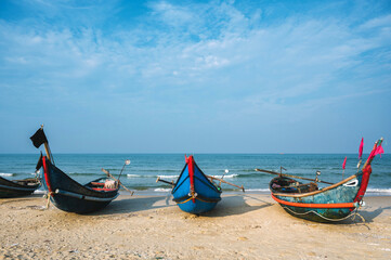 Traditional wooden Vietnamese boats on beach by sea in fishing village in Vietnam