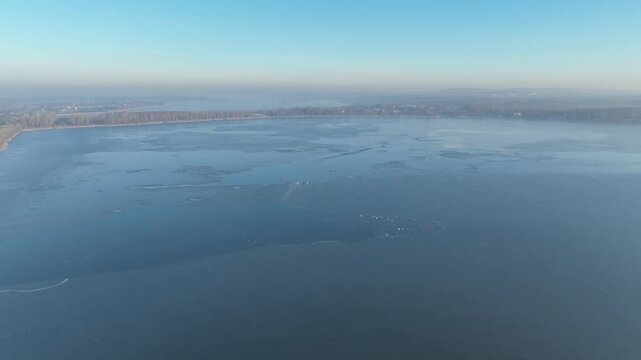 Frozen lake in the morning fog on a sunny day aerial shot from a drone. Pogoria lake in winter, Dabrowa Gornicza, Poland. Ice shrouded lake in fog.